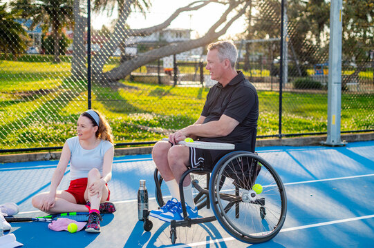 Participants of a wheelchair tennis rest in the court after the game