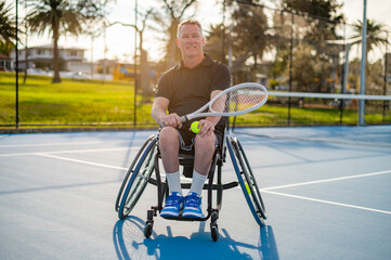 A skilled wheelchair tennis player practices on a blue court in a vibrant park during sunset