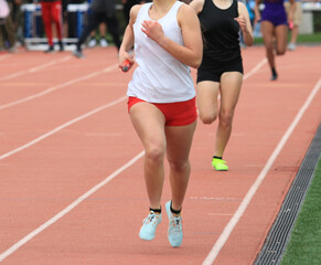 Female Runners Competing in a Relay Race at a Track Event