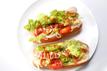 Tasty hot dog with vegetables and tomato isolated on white.