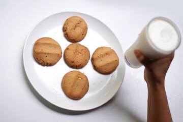 Tasty Biscuits and Milk Glass for Snack Time on White Surface.