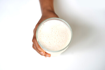 Hand holding Pure White Milk Glass Close-Up on White Background.