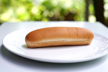 Plain hot dog bun close-up on white background.