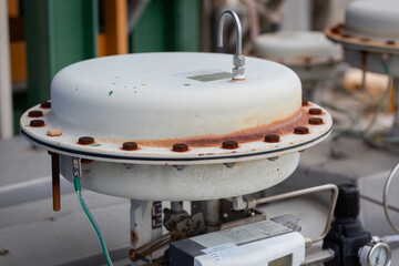 Control valve installed on a chemical pipeline with a large actuator head, used for opening,