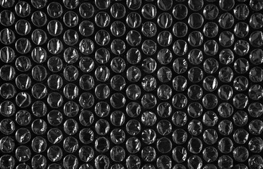 Close-up of plastic packaging shockproof bubbles texture on a black background.