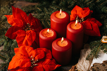 four burning Red advent candles in advent wreath decoration on wooden dark background. tradition in...