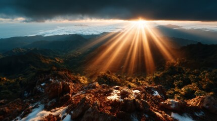 Experience the breathtaking beauty of a majestic sunset illuminating a mountain range with sharp rays of light piercing through the dramatic clouds in the background.