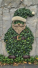 Festive Santa Claus Figure Covered in Green Ivy on a Textured Concrete Wall for Christmas Decoration