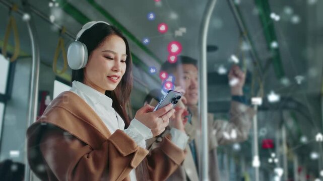 Asian woman wearing headphones smiling while scrolling smartphone on bus. Floating social media icons glowing around her. Man in background using phone. Modern communication in public transport.