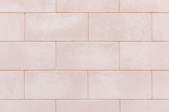 Beige tiled wall texture with subtle weathering effects