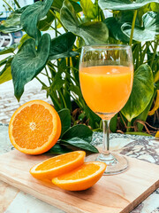 A glass of fresh orange juice with whole oranges placed beside it, refreshing and full of vitamin C, perfect for breakfast or a healthy lifestyle concept.