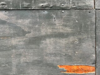 Weathered chipped boards, visible nails, orange paint, dark green and grey patina. Distressed surface for rustic or industrial background for design projects, posters, or digital artwork.