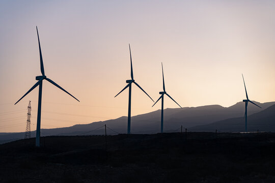 Wind turbines at sunset harness renewable energy