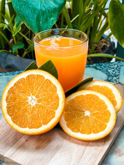 A glass of fresh orange juice with whole oranges placed beside it, refreshing and full of vitamin C, perfect for breakfast or a healthy lifestyle concept.