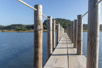 Naklejka premium Wooden boardwalk leading over obidos lagoon at nadadouro barrosa