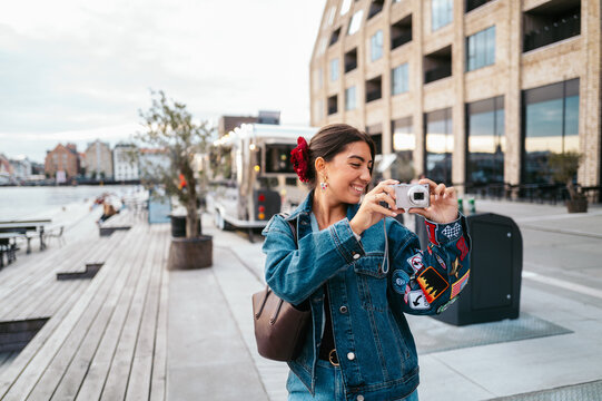 Woman capturing Copenhagen memories by the waterfront