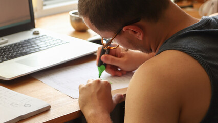 a man at a desk, using a marker to check items off a to do list, checklist. The setting is clean with a hint of green, symbolizing efficiency, organization, and the completion of tasks