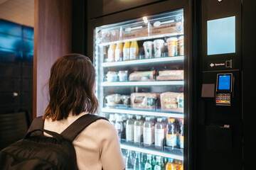 Traveler choosing snack from vending machine