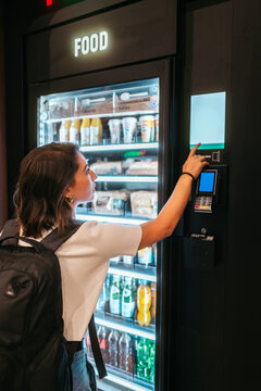 Woman using vending machine in travel setting