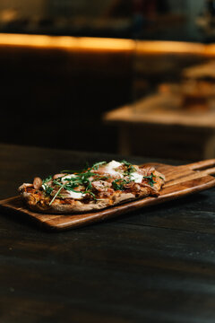 Delicious artisan pizza on a rustic wooden board