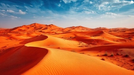 Naklejka premium Expansive desert landscape with flowing sand dunes under a bright blue sky