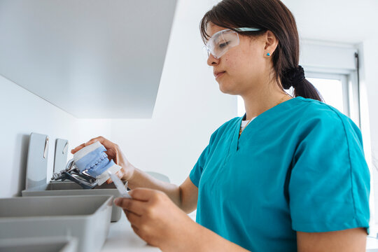 Female dental technician examining dental mold