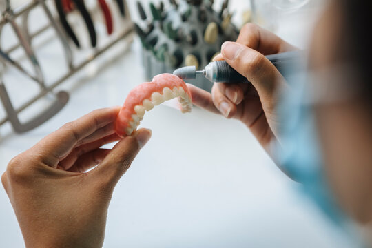 Female technician crafting dentures with precision