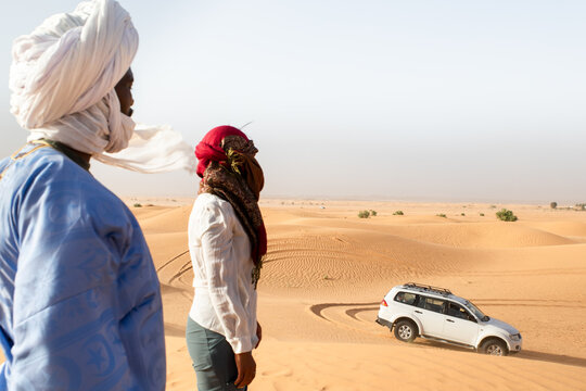 Tourist and tour guide enjoy Sahara exploration with traditional elements