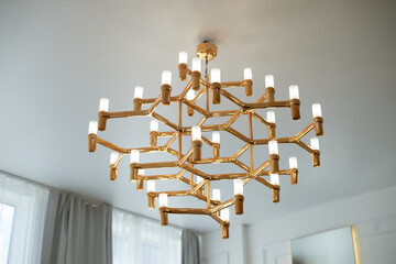 A golden chandelier with many light bulbs. Style, minimalism and luxury,