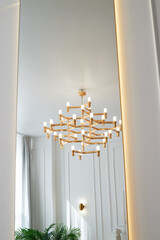 A golden chandelier with many light bulbs. Style, minimalism and luxury,