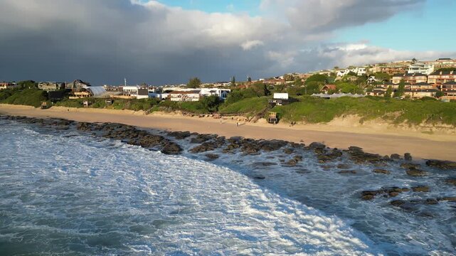 Aerial view of ocean waves with surfers surfing at Supertubes in Jeffreys Bay or J-Bay in South Africa on a sunny day.