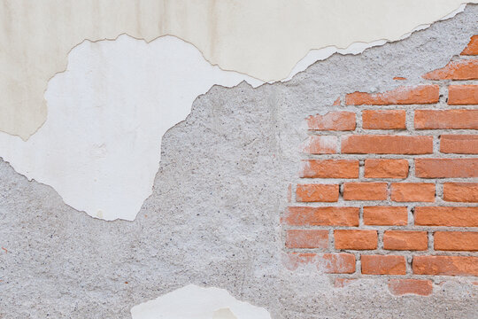 Textured wall surface with exposed bricks and plaster