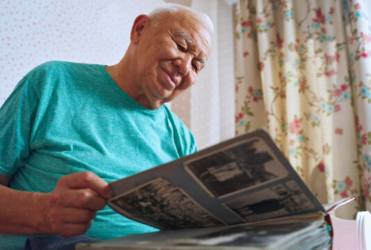 Elderly man enjoying a photo album at home