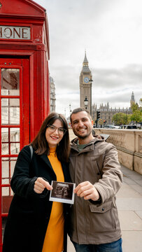Couple with ultrasound by London phone booth and Big Ben