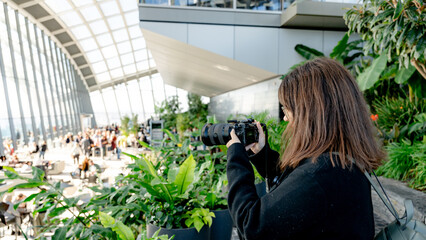 Woman photographing the lush Sky Garden indoor view