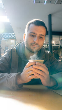 Man enjoying hot coffee in bustling marketplace