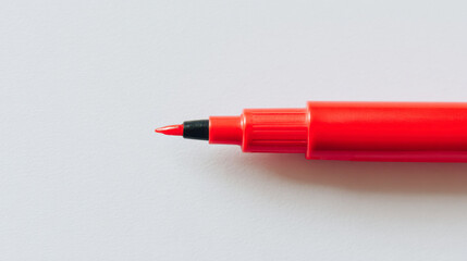 Bright red marker pen resting on a clean white background ready for creative tasks