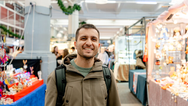 Man smiling at Covent Garden market stalls