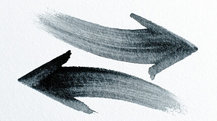 Brush arrows painted in soft black and gray tones on textured paper