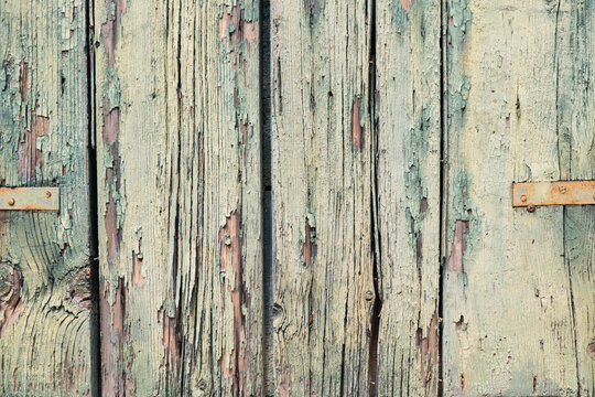Aged wood texture with peeling green paint and rusted hinges
