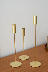 Gold candlesticks of different heights without candles. Minimalist style,