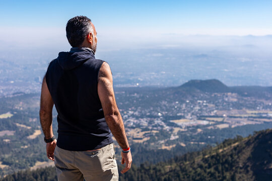 Back view of a man enjoying mountain view on a sunny day