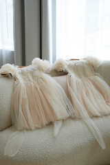 Tulle children's dresses on the sofa. Outfit for the holidays, preparation for a pleasant event
