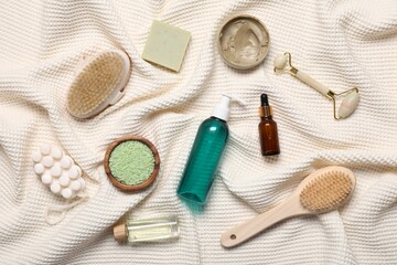 Flat lay composition with spa products and supplies on bathrobe