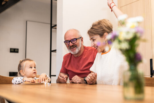 Grandparents enjoying a playful moment with granddaughter