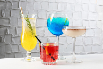 Glasses of tasty cocktails on white table