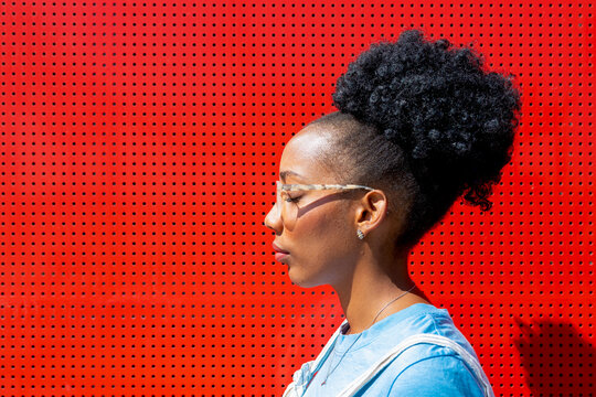 Profile of a woman against a vibrant red wall