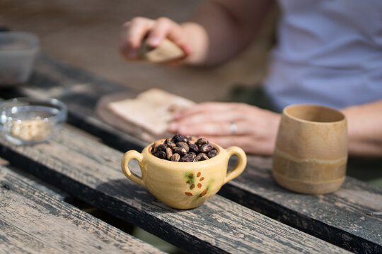 Man cracking pine nuts at a rustic outdoor table