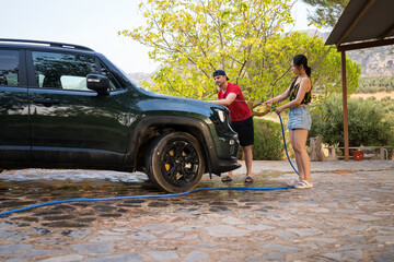 Washing SUV by hand at home on a sunny day