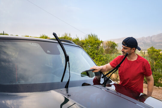 Washing SUV by hand outdoors at home